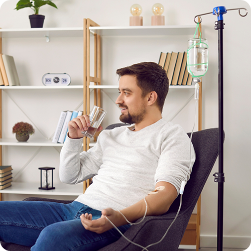Man drinking water with an IV in his arm